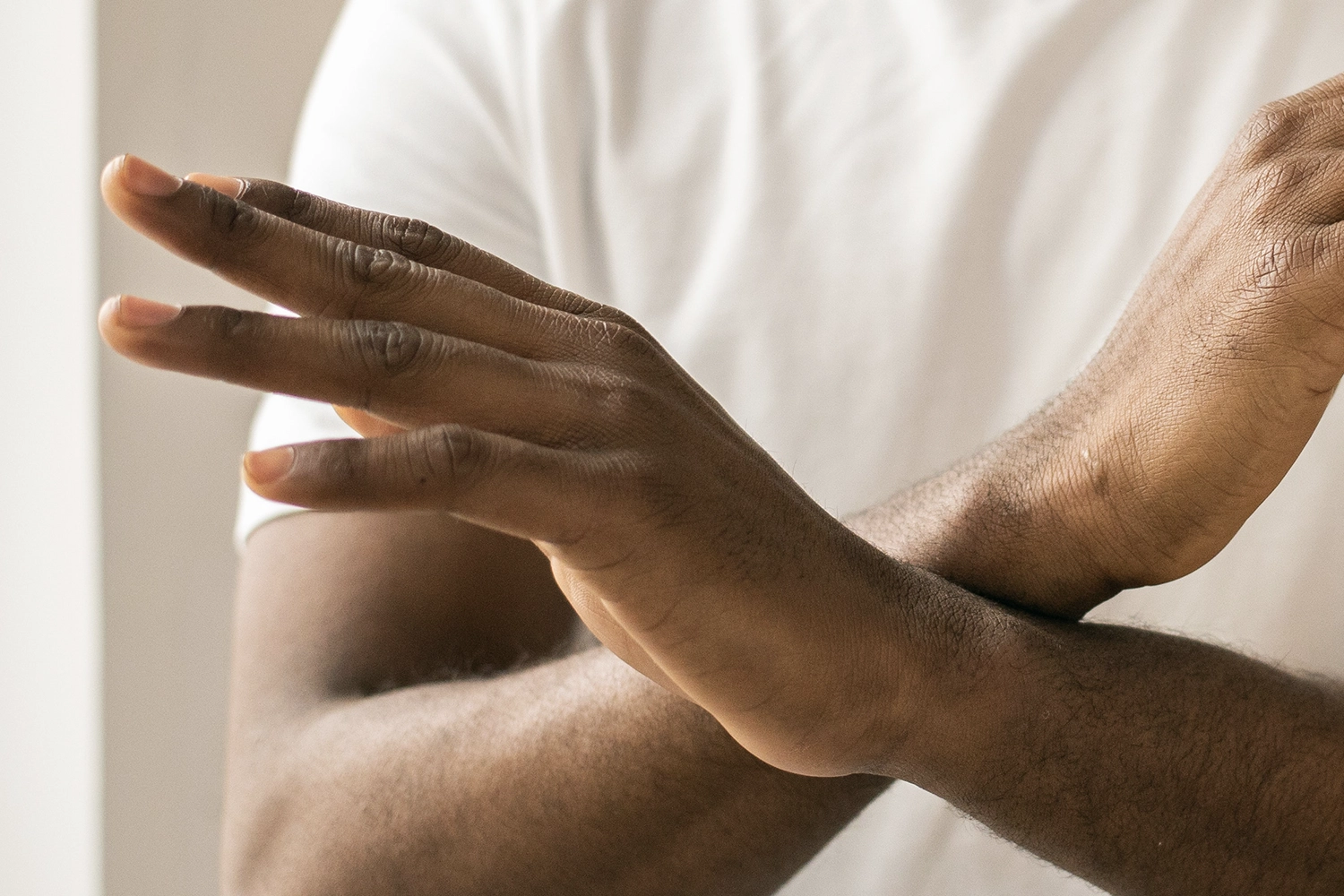 person with hands crossed in front of their ches